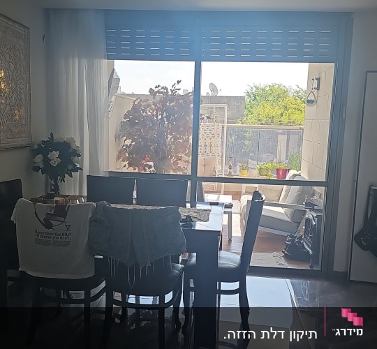 תריסים סגורים בחלון גדול בסלון ביתי
